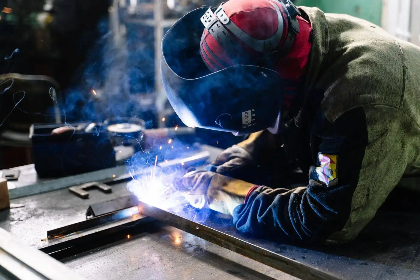 Metallbauer schweißt ein Stahlteil, Funken fliegen